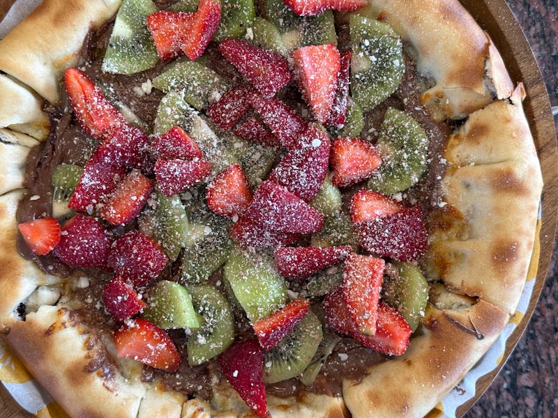 Pizza chef crafting authentic wood-fired pizza at Pizza Ranch